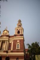A large red brick building with a clock tower photo