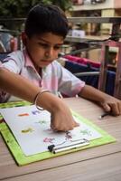 A young boy is drawing on a piece of paper photo