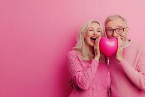 Smiling senior partners covering faces with heart-shaped balloon, radiating love during romantic celebration of enduring relationship photo