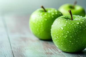 green apples with water droplets sits on a rustic wooden table. photo