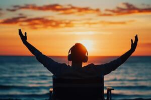 a young man with headset joyfully on beach , stretching his arms . focused on the open space, allowing for additional visuals.,, photo