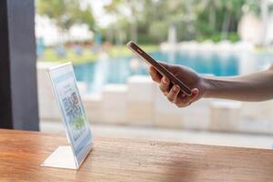 use smartphone to scan QR code for order menu in cafe restaurant with a digital delivery. Choose menu and order accumulate discount. E wallet, technology, pay online, credit card photo