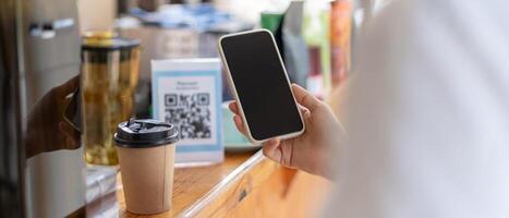 Woman use smartphone to scan QR code for order menu in cafe restaurant with a digital delivery. Choose menu and order accumulate discount. E wallet, technology, pay online, credit card. photo