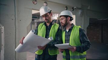 Glad Caucasian workers men guys holding draft papers mechanics working project architects plan build manufacture males engineers discuss construction in factory builders teamwork cooperation handshake video
