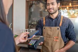Happy Owner recieve scan QR code to pay in cafe restaurant with a digital payment without cash. Choose menu and order accumulate discount. E wallet, technology, pay online, credit card, bank app. photo