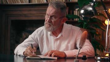 pensativo pensativo antiguo caucásico hombre escritura notas a hacer lista cuaderno diario masculino pensionista empresario pensando contemplar negocio oficina adentro escribir solución planificación reflexionar trabajador encontrar responder video
