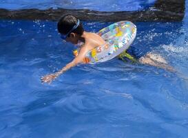A boy swimming in a pool with an inflatable ring photo