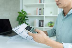 man use phone to scan barcode or QR codes to pay credit card bill after receiving document invoice online. payment, receive, paying electricity, digital payments without money, technology. photo