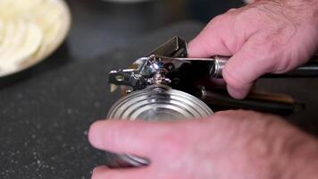 open a tin can with a can opener Top view man's hands opening corn jar. Canned sweet corn in metallic jar isolated on dark background. video