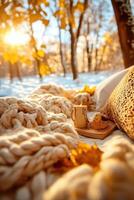 A blanket and coffee cup are on a blanket in the snow photo