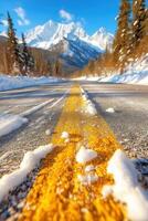 A road with snow on the ground and yellow lines photo