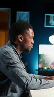 Vertical Self employed person working from home and researching different topics, examining online archived information and planning his daily tasks. Remote job setup increasing productivity. Camera A. video