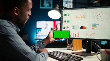 Young person does remote work using data finances with a green screen, examining statistics at his workstation. Investment advisor planning new strategy to obtain funds for development. Camera A. video