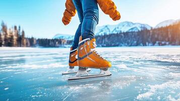 A person wearing orange skates on a frozen lake photo