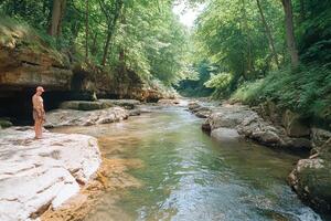 A man standing on a rock in a river photo