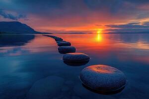 Large smooth stones lie in the sea at sunset, creating a path. The concept of harmony photo