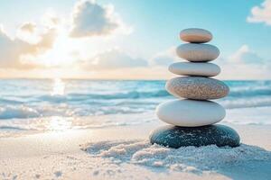 Stack or pyramid of smooth white stones on sand at seaside with blurred background. Balanced rocks on a blurred seascape with space for text. photo