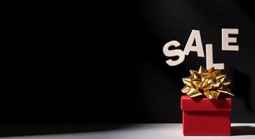 Creative gift box adorned with a golden bow signifies a sale. Captures attention with its vibrant colors photo