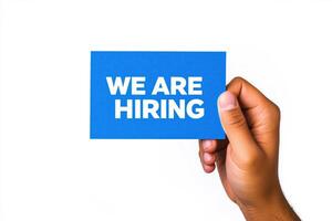 Blue WE ARE HIRING Sign Held by Hand with White Background and Professional Minimal Design photo