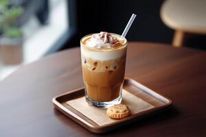 Glass of iced latte with whipped cream and cocoa served on a wooden tray with a butter cookie photo