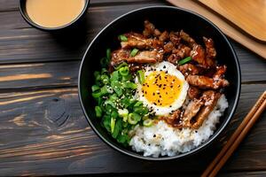 Delicious teriyaki beef rice bowl topped with fried egg, green onions, and sesame seeds photo