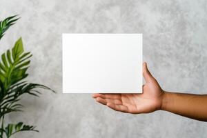 Hand Holding Blank Card Against Indoor Background, Concept for Message or Display with Neutral Indoor Setting photo