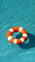 Bright Orange Lifesaver Floating in Clear Blue Pool Water, Summer Safety Concept photo