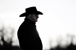 Silhouette of a man in a cowboy hat against a bright background. photo