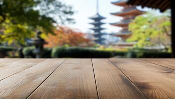 A blurred background of pagodas with a wooden table in the foreground. photo