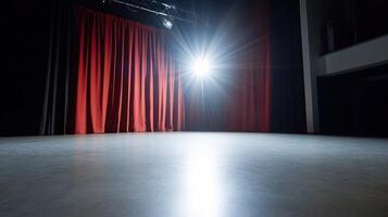 A spotlight illuminates an empty stage with red curtains in the background. photo