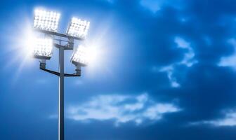 Bright stadium floodlights illuminating a cloudy evening sky. photo