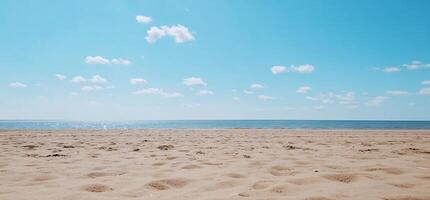 A serene beach scene with sand, water, and a clear blue sky. photo