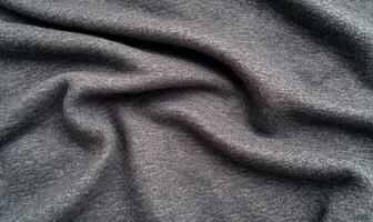 A close-up view of soft, textured gray fabric draped elegantly. photo