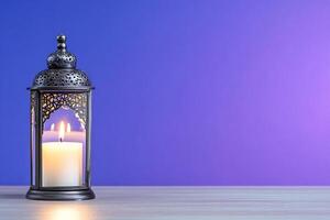A decorative lantern with a candle on a wooden surface against a gradient background. photo