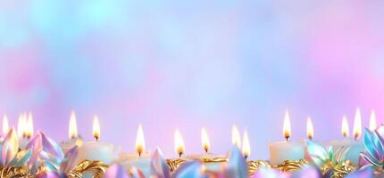 A serene display of lit candles with a colorful, blurred background. photo