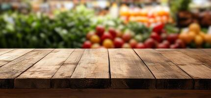 A wooden table in front of a blurred market with fruits and vegetables. photo