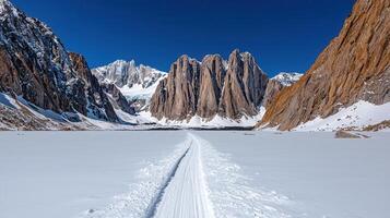 Scenic Winter Trail Through Snow Covered Valley with Majestic Mountain Peaks photo