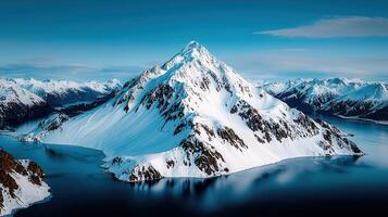 Majestic Snow Capped Mountain Peak Surrounded by Serene Glacial Lake and Snowy Mountain Range photo
