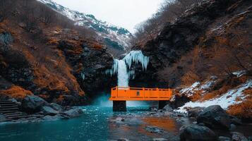Stunning Orange Bridge Over Winter Waterfall in Mountainous Landscape photo