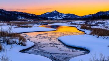 Serene Winter Sunset Frozen River Winding Through Snowy Landscape with Mountain Range photo