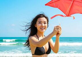 A woman in a bikini holding a red kite photo