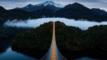 Majestic Mountain Suspension Bridge Over Misty Lake and Forest photo