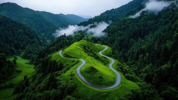 Scenic Winding Road through Lush Green Mountain Valley Landscape Aerial View photo