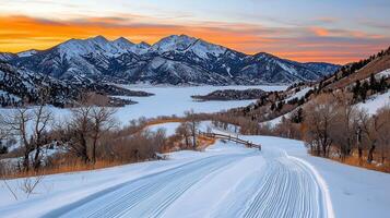 Scenic Winter Sunset over Frozen Lake and Mountain Range with Cross Country Ski Tracks photo