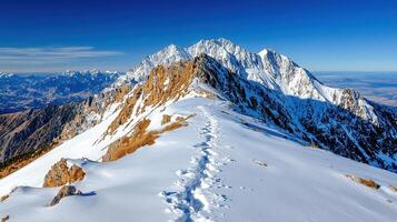 Majestic Winter Mountain Peak Trail Snow Covered Ridge with Footprints Panoramic View photo
