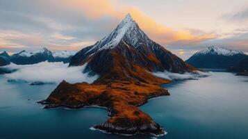Majestic Snow Capped Mountain Peak at Sunrise Over Serene Fjord and Island photo