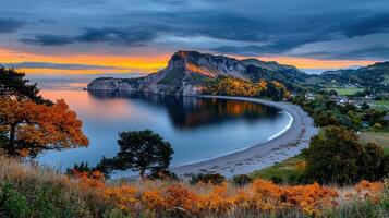 Stunning Autumnal Bay Landscape Coastal Scene with Mountain Beach and Colorful Trees at Sunset photo