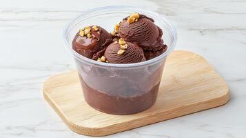 Delicious Chocolate Ice Cream Scoops with Hazelnuts in a Clear Plastic Cup photo