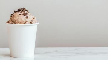 Delicious Chocolate Ice Cream Scoop in White Cup Marble Table Background photo