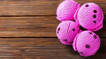 Delicious Pink Chocolate Chip Ice Cream Scoops on Rustic Wood Background photo